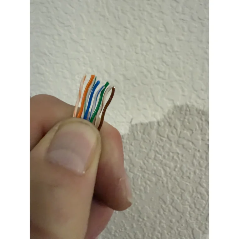 Ethernet cable termination detail showing twisted pairs before connector work.