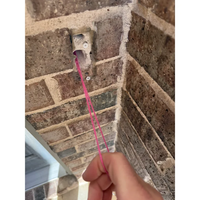 Low-voltage wiring routed near a brick wall outlet location.