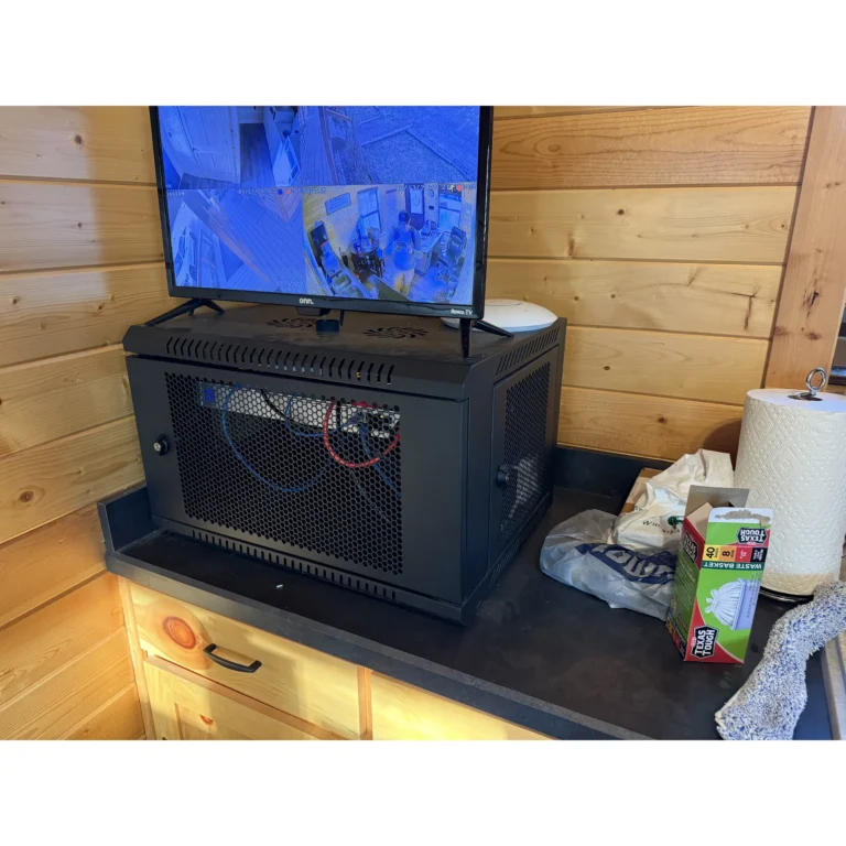 Wall-mounted network rack setup for organized equipment and cabling.
