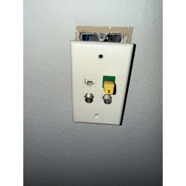 Low-voltage wall plate wiring detail with connector and exposed cable.