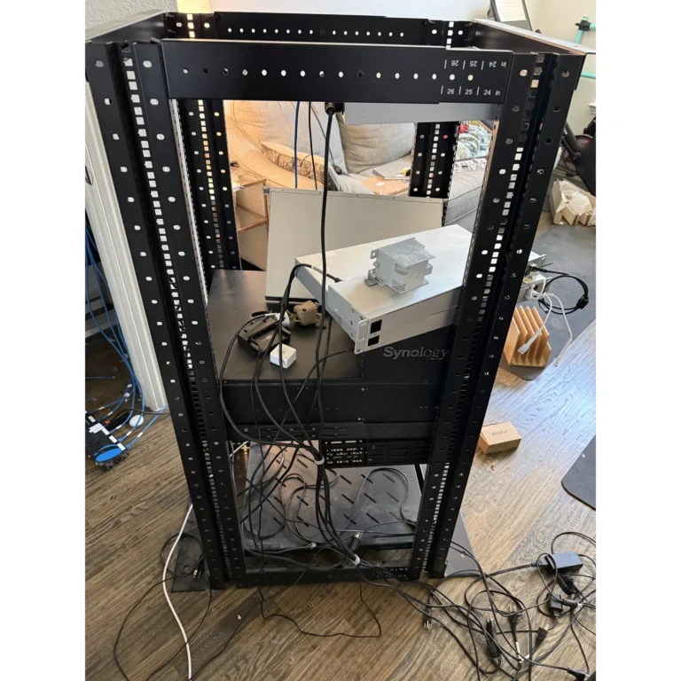 Open network rack during equipment setup and cabling work.