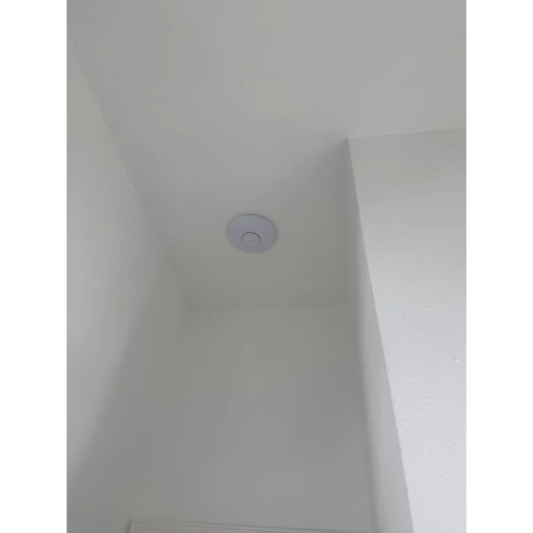 Ceiling-mounted smart device installed during a connected home or business technology project.