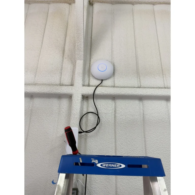 Ceiling-mounted Wi-Fi access point and cabling prepared during a wireless network installation.