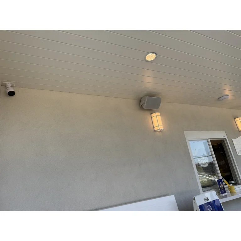 Exterior security camera and low-voltage device installed under a covered entry area by Texas 67 Systems.
