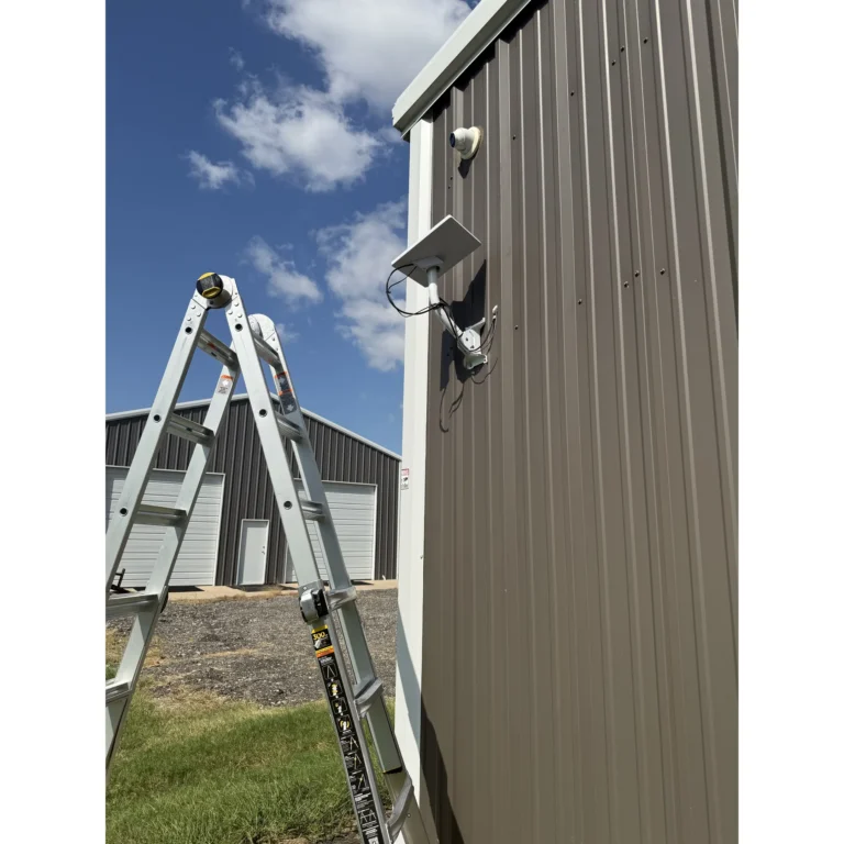 Exterior security light and camera mounted on a metal building during a Texas 67 Systems field project.